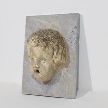 Carved stone cherub fountain head on marble panel, Italy circa 1650-1750