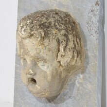 Carved stone cherub fountain head on marble panel, Italy circa 1650-1750